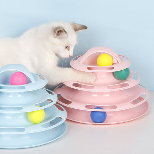 a cat sitting on a table next to a cake 